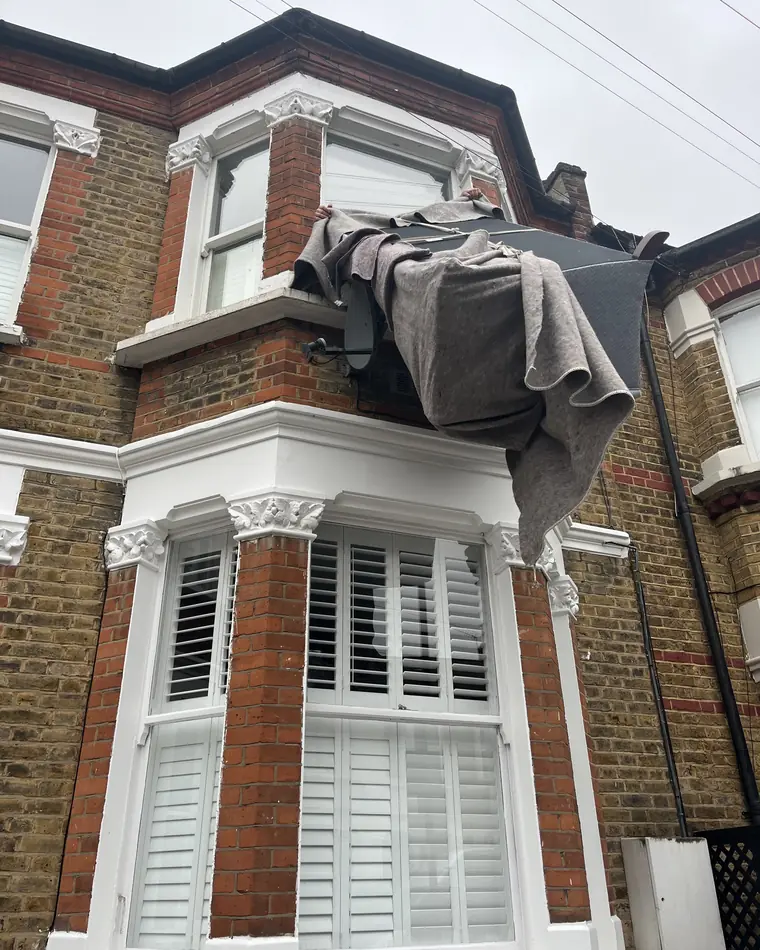 The wrapped sofa going in through the upstairs window